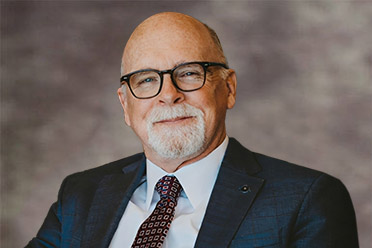Headshot of Stuart Cearley, Esq., bald man with glasses and beard.