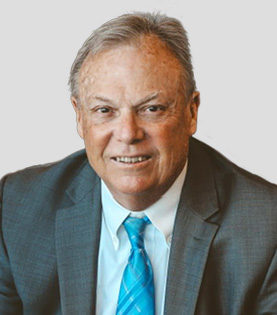 Headshot of Attorney Greg Clark in a grey suit and blue plaid tie.