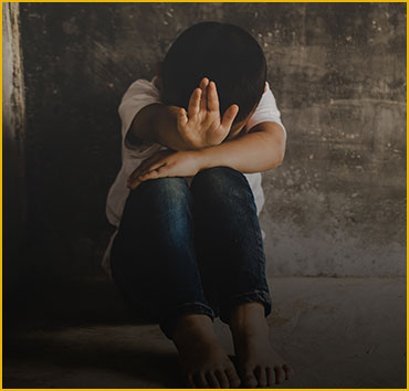 Child shielding face: Symbolizing assault and battery legal issues.