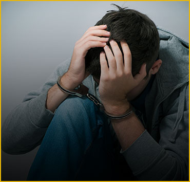 Teenager in handcuffs, hands on head: Representing juvenile crimes.