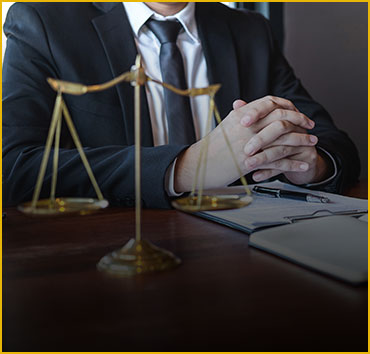 Scales of justice on a desk with a person in a suit: Legal resources.