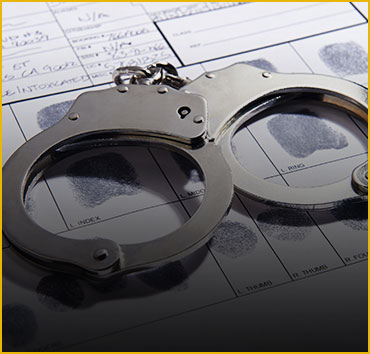 Handcuffs on papers with fingerprints, for extradition & arrest warrants.