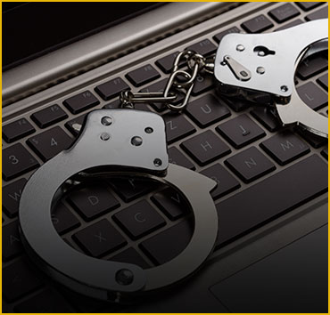 Handcuffs on a laptop keyboard, for computer & internet crimes.