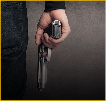 Hand holding a handgun, symbolizing weapons and gun offenses.