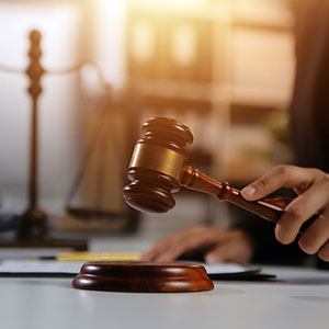Gavel striking block, symbolizing law, justice, and legal decisions.