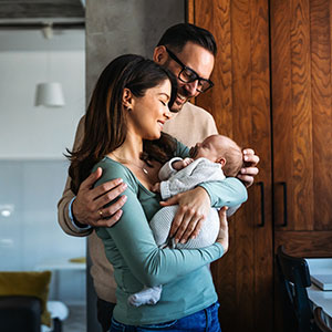 Happy parents holding a baby, symbolizing family law and adoption.