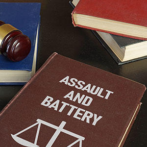 Law book titled "Assault and Battery" with a gavel, representing legal defense.