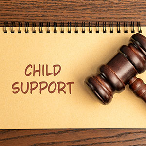 Gavel on a notebook with "Child Support" written, symbolizing legal aid for child support.