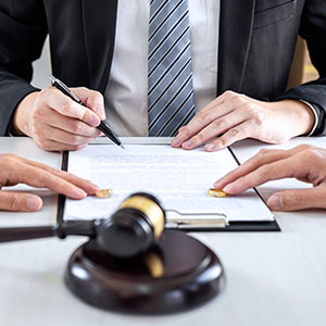Couple and attorney with divorce papers and gavel, symbolizing divorce legal services.