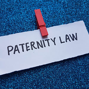 Paper with "Paternity Law" written on it, clipped to a blue background.
