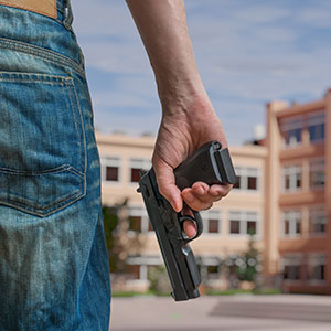 Person holding a handgun, representing weapon and gun offenses defense.