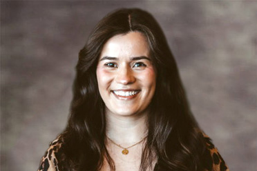 Legal Assistant Victoria Rowe smiling in a leopard print blouse.